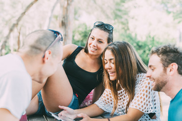 Group of friends millennials sitting pinewood using digital devices - technology, interaction,...