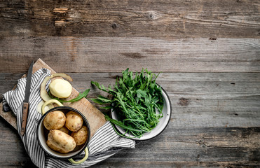 Young potatoes and fresh arugula, topview, textspace left