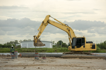 Excavator on a construction site. Yellow excavator at the construction of a new swimming pool in...