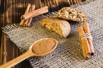 Pieces of oatmeal cookies and cinnamon on the rustic wooden background