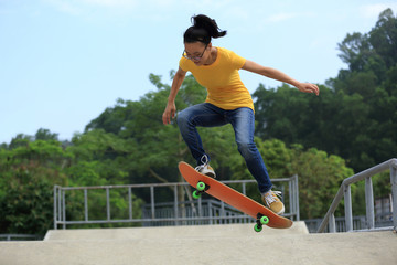 young woman skateboarder skateboarding at skatepark