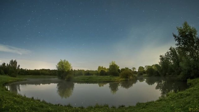 Time lapse of stars moving above creek