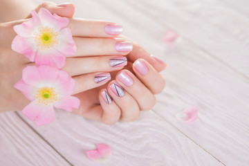 Obraz na płótnie Canvas Beautiful pink manicure with silver triangles