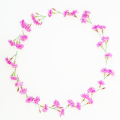 Frame wreath made of pink flowers on white background. Flat lay, top view. Floral pattern