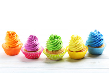 Tasty cupcakes on a white wooden table