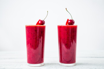 Cherry smoothie and tasty berries on white background. Fresh natural milkshake