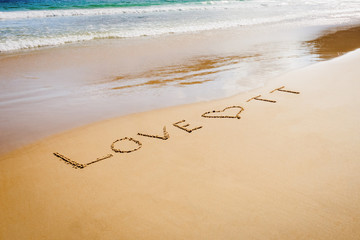 Word Love TT Trinidad and Tobago written on the beach sand in Maracas Bay Beach