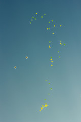 many bright baloons flying in the blue sky