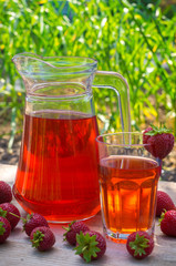 glass with strawberry juice and berries isolated on blur background