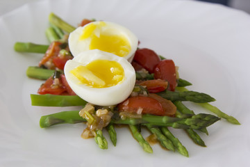 Green asparagus with a spicy vegetable sauce and boiled egg - breakfast for health