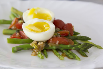 Green asparagus with a spicy vegetable sauce and boiled egg - breakfast for health