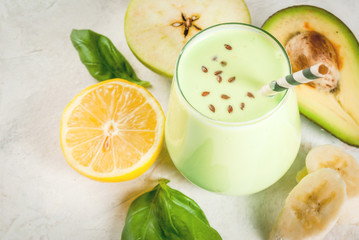 Healthy food. Dietary breakfast or snack. Green smoothies from yoghurt, avocado, banana, apple, spinach and lemon. On white concrete stone table, with ingredients. Copy space