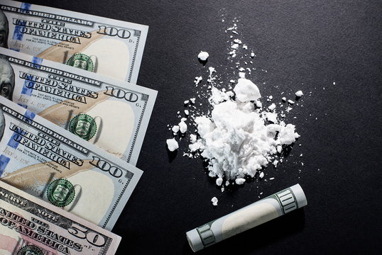 Cocaine and dollars on a black background