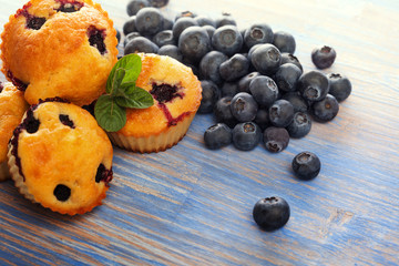 muffin with blueberries on a wooden table. fresh berries and sweet pastries on the board