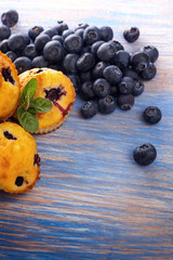 muffin with blueberries on a wooden table. fresh berries and sweet pastries on the board.