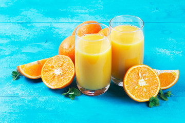 Orange juice - two glasses on blue wooden table background
