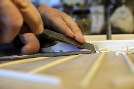 Artigiano falegname lavora il legno con attrezzo in mano