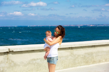 Mother and baby walking along the seafront