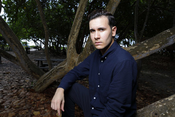 Handsome Hispanic man posing in a park setting