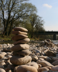 Steinturm am Fluss mit Straßenbrücke im Hintergrund