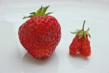 Still life, two berries - strawberry and wild strawberry -on a white background 