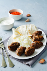 Minced meat sausage with onion, sour cream and red bell pepper relish. Cevapi with Ajvar sauce