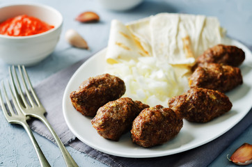 Minced meat sausage with onion, sour cream, pita and red bell pepper relish