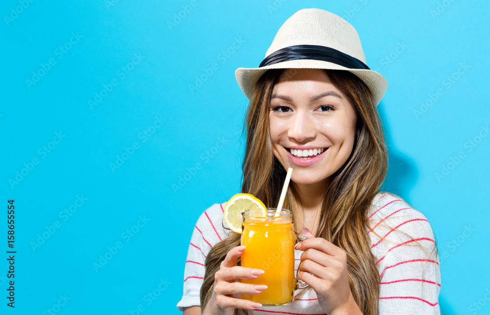 Wall mural happy young woman drinking smoothie