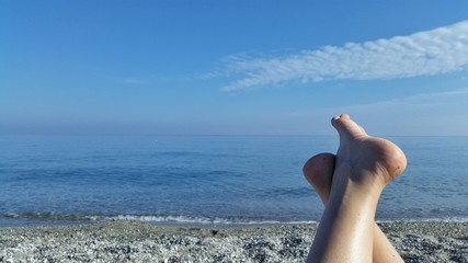 Girl sunny feet near the sea