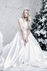 Fototapeta na wymiar snow queen in white dress in ice room
