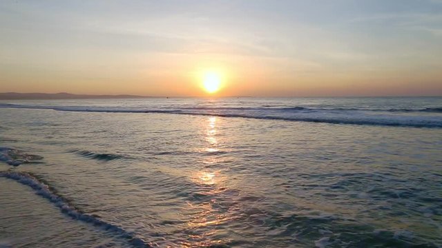 Sea scenery golden sunrise over horison. Dark waves go to sandy beach. Sound of nature. Ocean horizon beautiful background sea scene. Ocean waves blue water shine by sun light morning sunrise