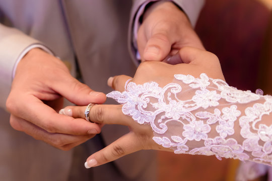 Close Up Hands Of Bride And Groom Putting On A Wedding Rings