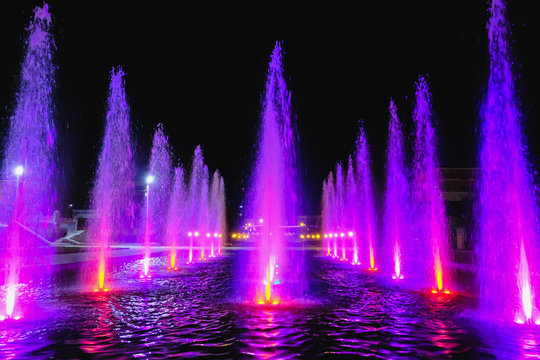 colored water fountain at night
