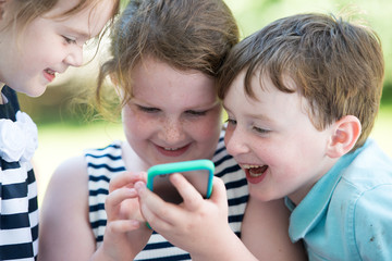 Happy Laughing Children Playing with Smartphone Outside