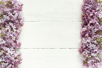 Bouquet of lilac flowers on white wooden background.