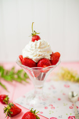 Obraz na płótnie Canvas Summer dessert: strawberries and cream on a wooden table