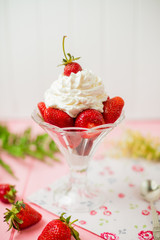 Summer dessert: strawberries and cream on a wooden table