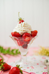 Summer dessert: strawberries and cream on a wooden table