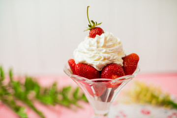 Summer dessert: strawberries and cream on a wooden table