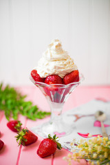 Summer dessert: strawberries and cream on a wooden table
