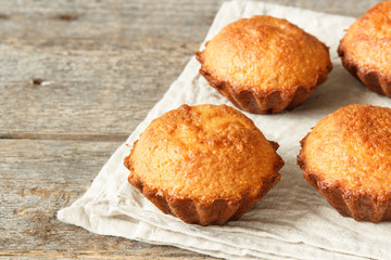 A few muffins in the baking dish. Wooden background.
