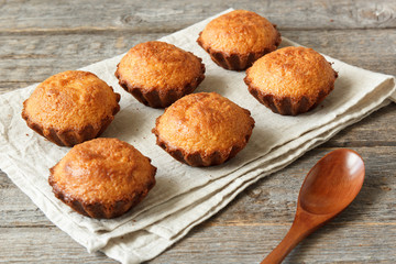 A few muffins in the baking dish. Wooden background.