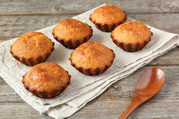 A few muffins in the baking dish. Wooden background.