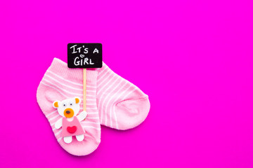 Baby Girl - pink and white socks with bear on pink background with It's a Girl blackboard sign
