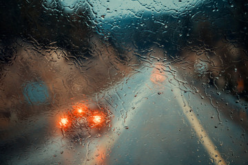 Fototapeta premium blurry cars and lights in traffic in a rainy evening seen through windscreen