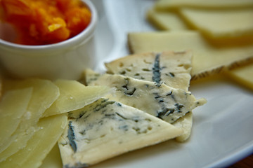 Cheese plate with different kinds of cheese with thyme herbs and walnuts. Mix cheese on wooden board with grapes. Top view..