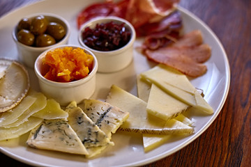 Cheese plate with different kinds of cheese with thyme herbs and walnuts. Mix cheese on wooden board with grapes. Top view..