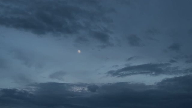 Moon and black clouds run through the spring sky before the storm 