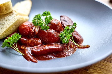 warm salad with chicken liver and grapes on the white plate. Warm salad from turkey liver. Warm salad with chicken liver in raspberry sauce.