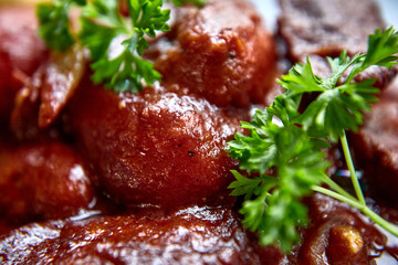 warm salad with chicken liver and grapes on the white plate. Warm salad from turkey liver. Warm salad with chicken liver in raspberry sauce.